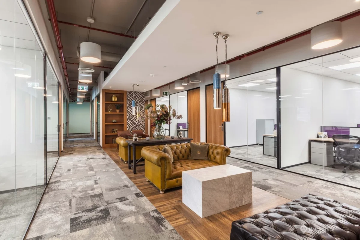 Modern office hallway with stylish furniture and glass-enclosed offices