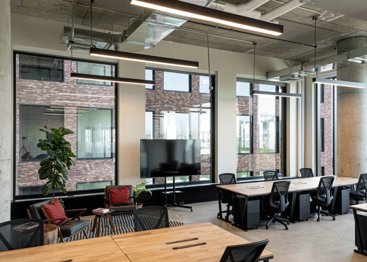 Modern coworking space in Singapore with wooden desks, ergonomic chairs, and large windows.